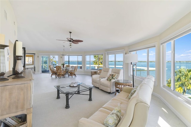 living room with a water view and ceiling fan