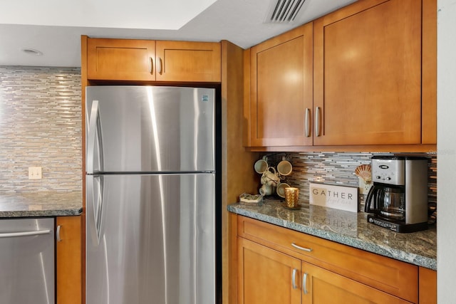 kitchen with stone countertops, backsplash, and appliances with stainless steel finishes