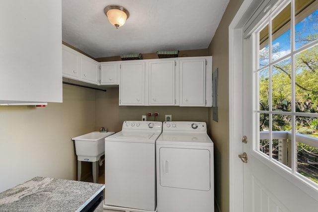 laundry area featuring washer and clothes dryer and cabinets