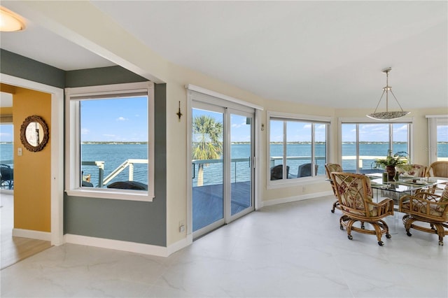 sunroom featuring a water view