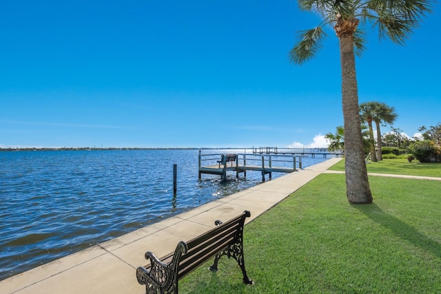 dock area with a water view and a lawn