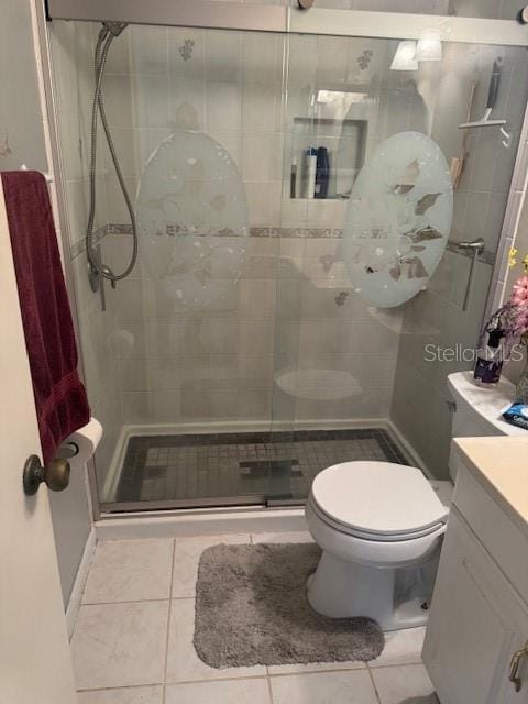 bathroom with vanity, toilet, tile patterned floors, and a shower with shower door