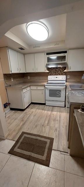 kitchen featuring sink, white cabinetry, a tray ceiling, and white electric range