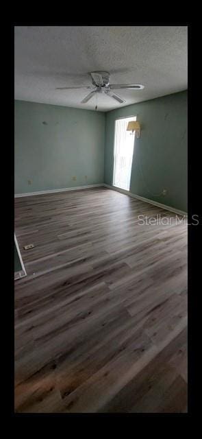 spare room featuring ceiling fan, hardwood / wood-style floors, and a textured ceiling