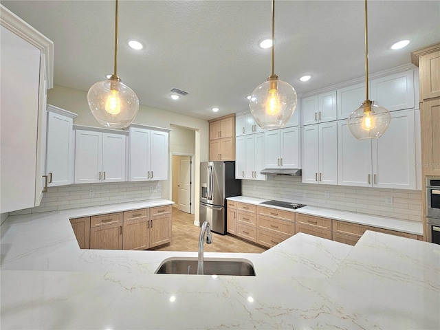 kitchen with pendant lighting, stainless steel fridge, and white cabinets