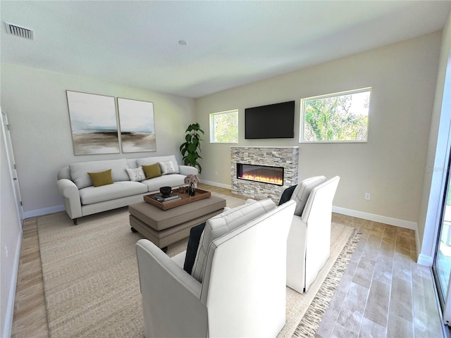 living room with light wood-type flooring and a stone fireplace