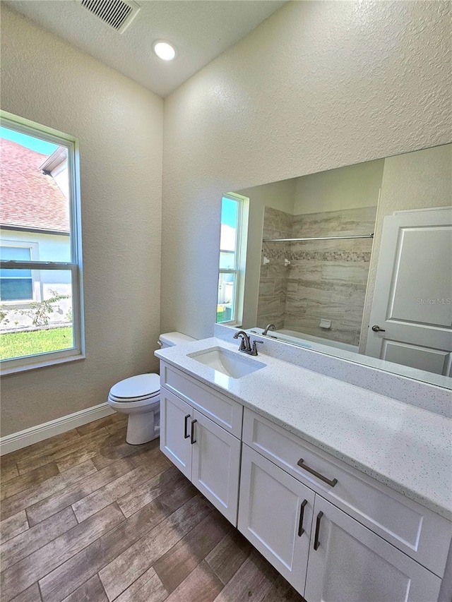 bathroom featuring vanity, toilet, and tiled shower