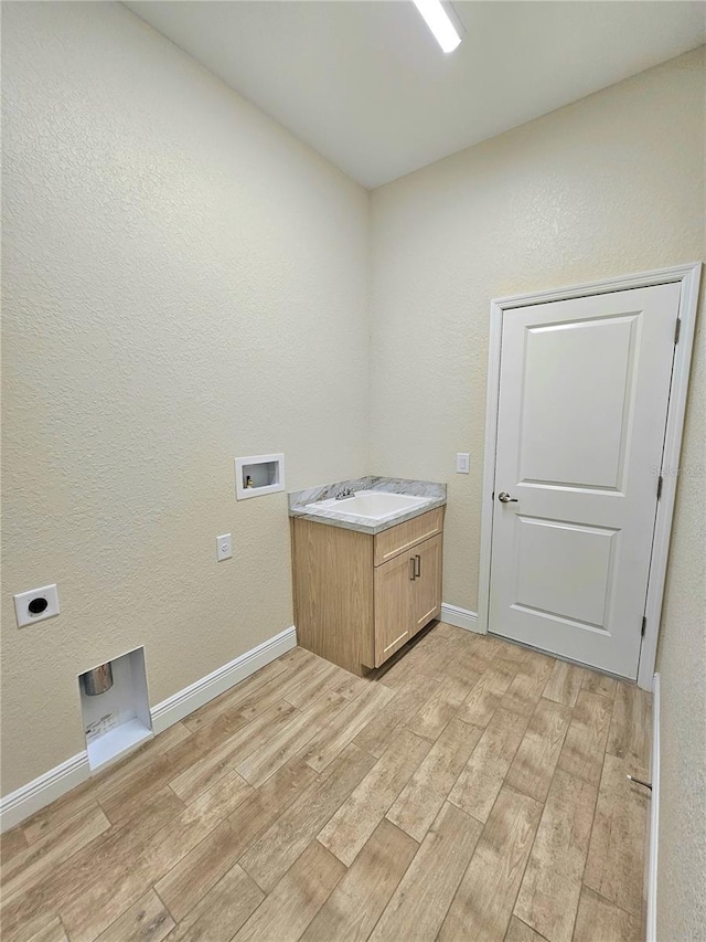 laundry area featuring hookup for an electric dryer, washer hookup, light hardwood / wood-style flooring, and cabinets