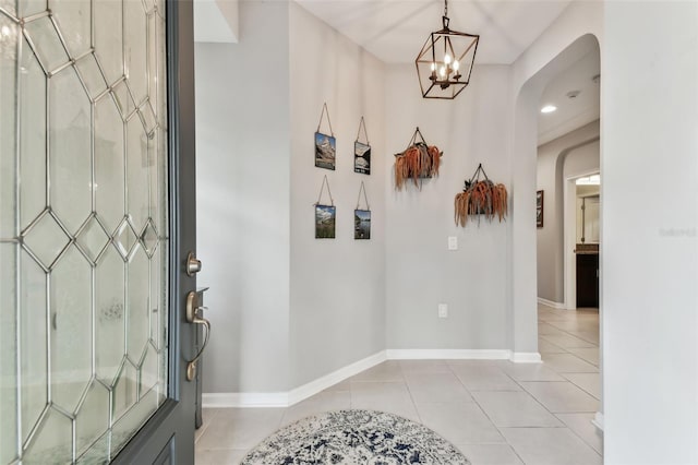 tiled entryway featuring an inviting chandelier