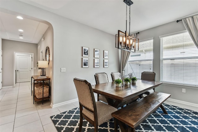 tiled dining area featuring a chandelier