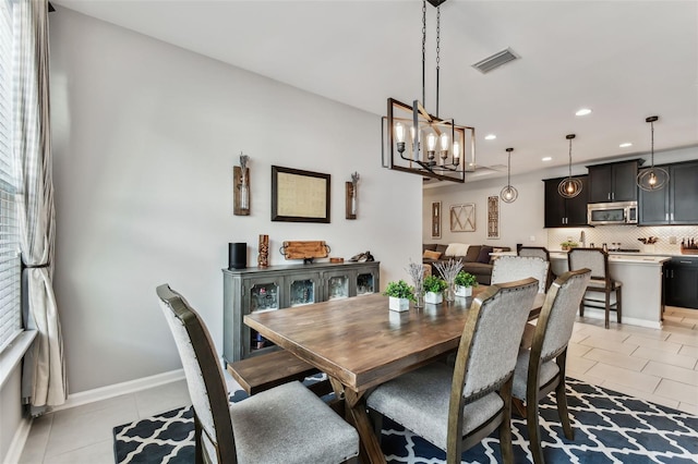 dining area featuring light tile patterned floors and an inviting chandelier