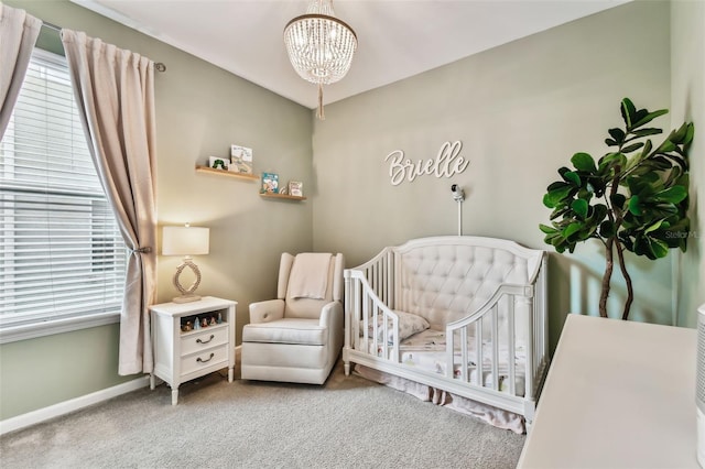 bedroom featuring carpet, an inviting chandelier, and a nursery area