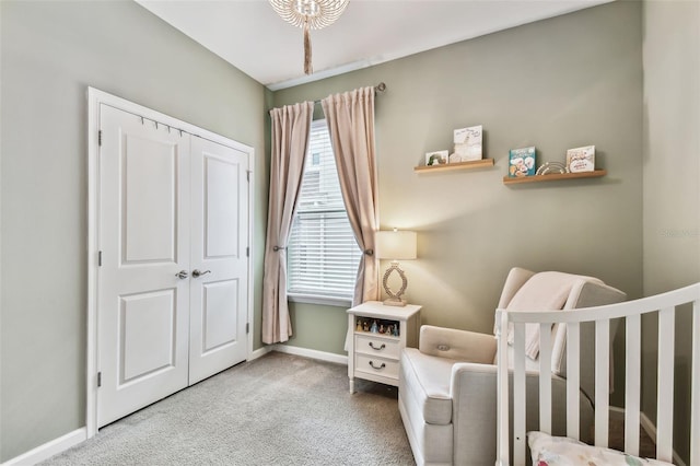 carpeted bedroom featuring a crib and a closet