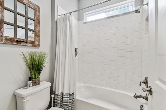 bathroom featuring shower / tub combo and toilet