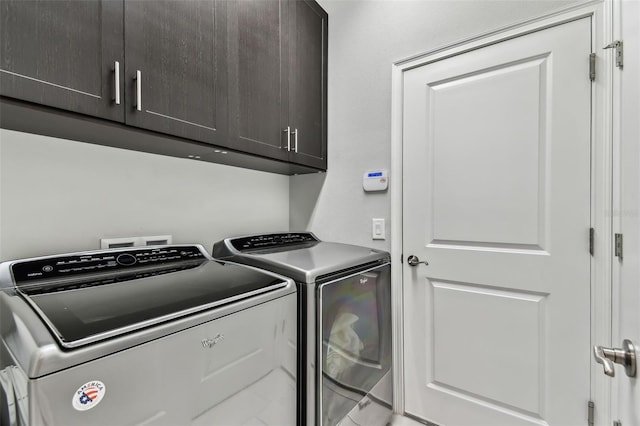 laundry room with washer and clothes dryer and cabinets