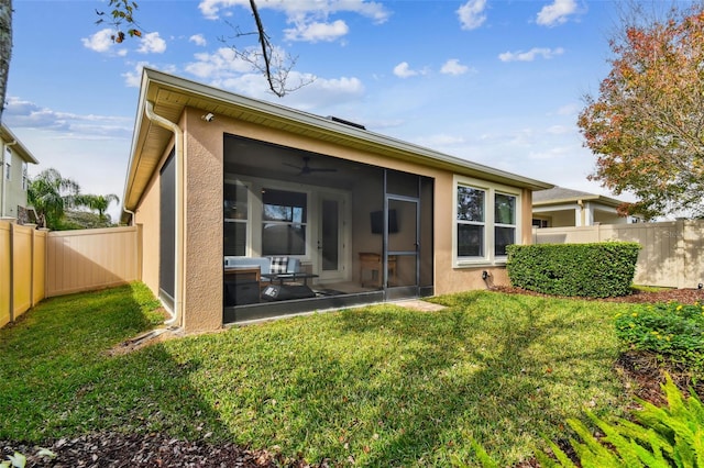 rear view of house with a sunroom and a yard