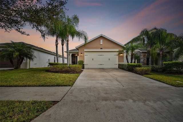 single story home featuring a lawn and a garage