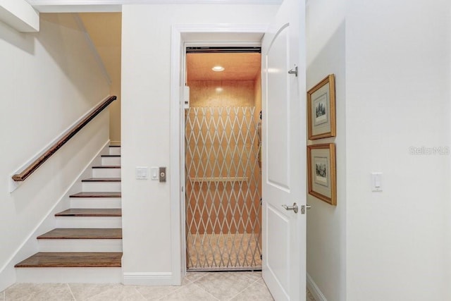 stairs with tile patterned flooring and elevator