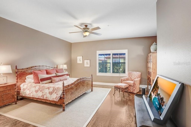 bedroom with ceiling fan and hardwood / wood-style flooring