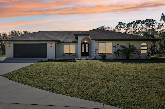 view of front of home with a garage and a lawn