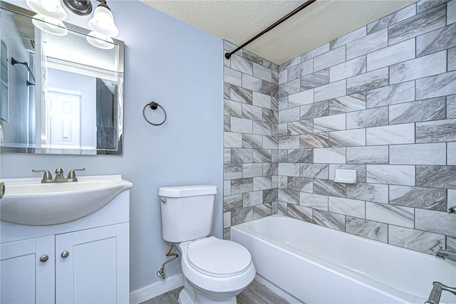 full bathroom featuring vanity, a textured ceiling, toilet, and tiled shower / bath