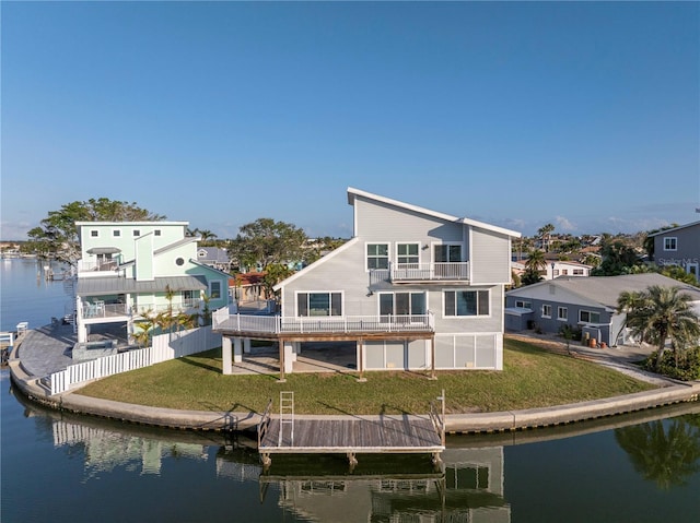 back of property featuring a water view, a balcony, and a lawn