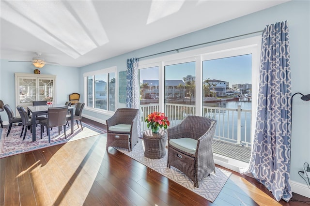 sunroom featuring a water view, plenty of natural light, and ceiling fan