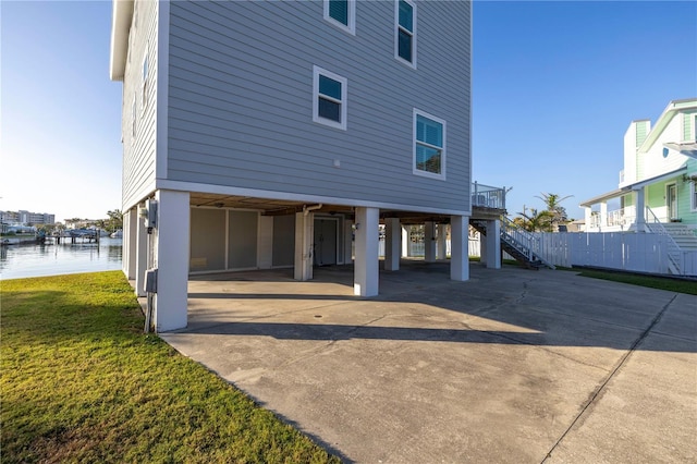 back of house with a carport and a water view