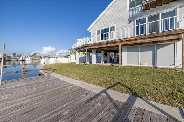 view of dock featuring a lawn and a deck with water view