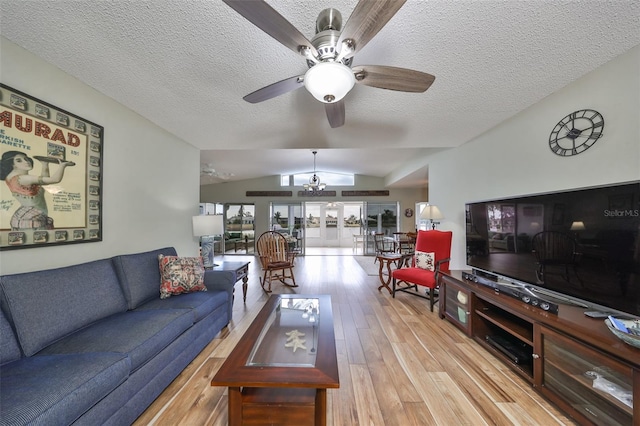 living room featuring ceiling fan, lofted ceiling, light hardwood / wood-style flooring, and a textured ceiling