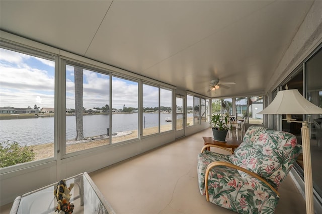 sunroom / solarium featuring a water view and ceiling fan