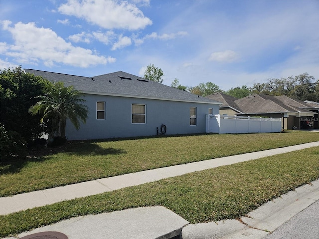 view of side of home with a yard