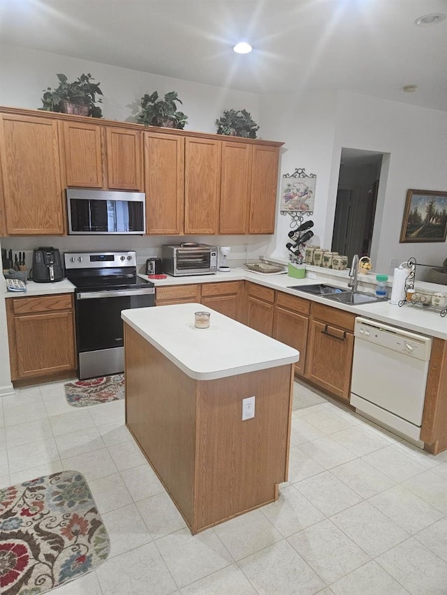 kitchen featuring kitchen peninsula, stainless steel appliances, a kitchen island, and sink