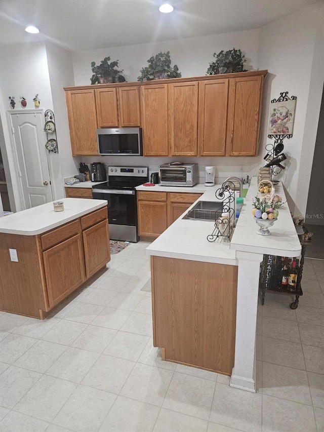 kitchen with light tile patterned floors, a center island, stainless steel appliances, and sink