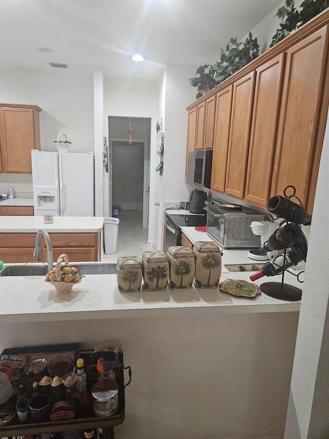 kitchen featuring stainless steel electric stove, white fridge with ice dispenser, and sink