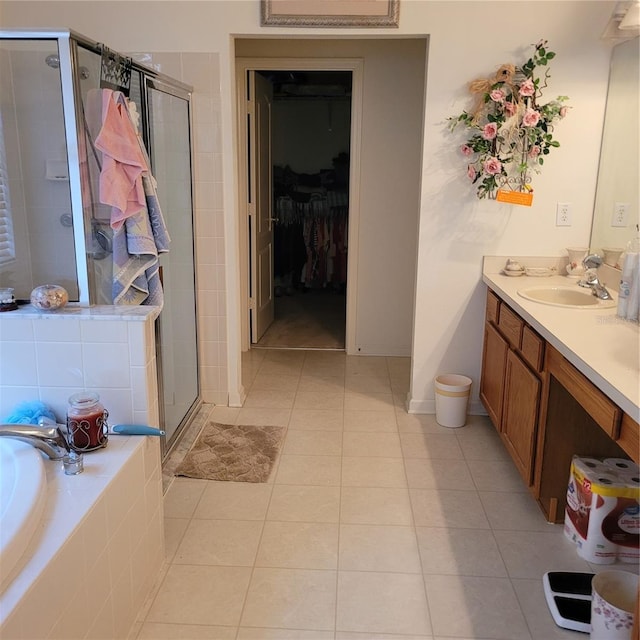 bathroom with tile patterned flooring, shower with separate bathtub, and vanity