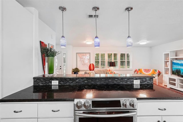 kitchen featuring stove, white cabinets, and hanging light fixtures