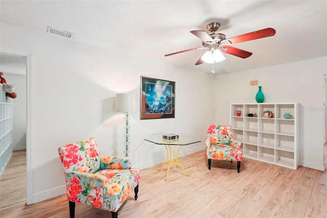 sitting room with ceiling fan and hardwood / wood-style floors