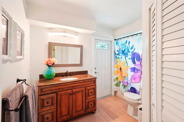 bathroom featuring a shower with shower curtain, vanity, toilet, and wood-type flooring