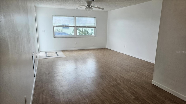 empty room featuring a textured ceiling, ceiling fan, and dark wood-type flooring