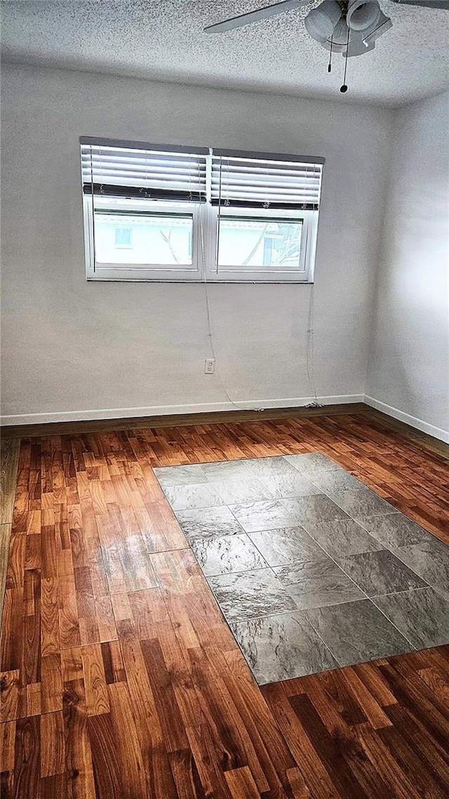 empty room with hardwood / wood-style floors, ceiling fan, and a textured ceiling