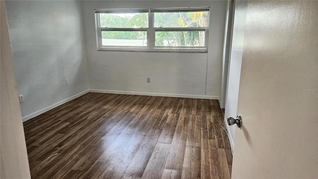 unfurnished room featuring dark wood-type flooring