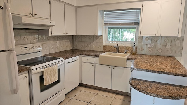 kitchen with white appliances, sink, tasteful backsplash, light tile patterned flooring, and white cabinetry