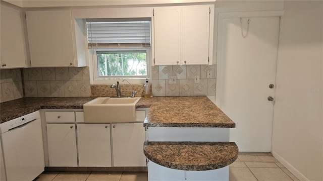 kitchen with white cabinets, decorative backsplash, white dishwasher, and sink