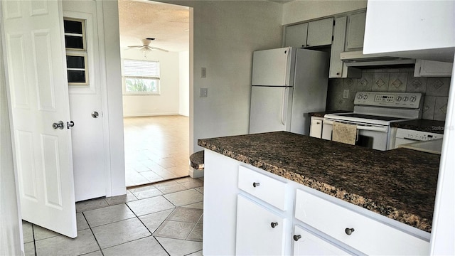 kitchen with white appliances, decorative backsplash, ceiling fan, light tile patterned floors, and white cabinetry