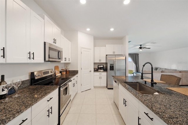 kitchen with white cabinetry, sink, appliances with stainless steel finishes, and dark stone counters