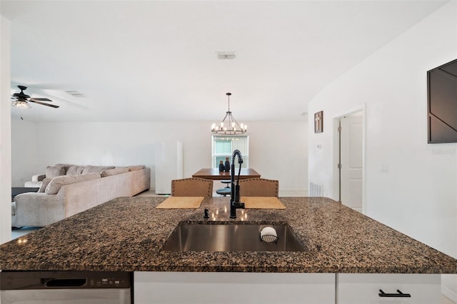 kitchen featuring sink, stainless steel dishwasher, dark stone counters, decorative light fixtures, and ceiling fan with notable chandelier