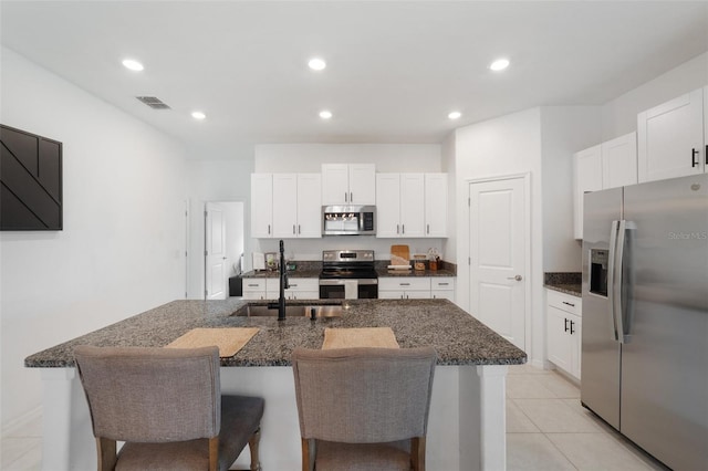 kitchen featuring white cabinets, sink, an island with sink, and appliances with stainless steel finishes