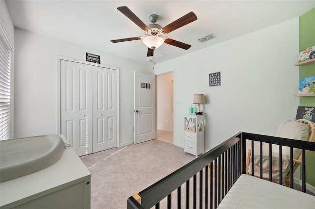 carpeted bedroom featuring ceiling fan and a closet