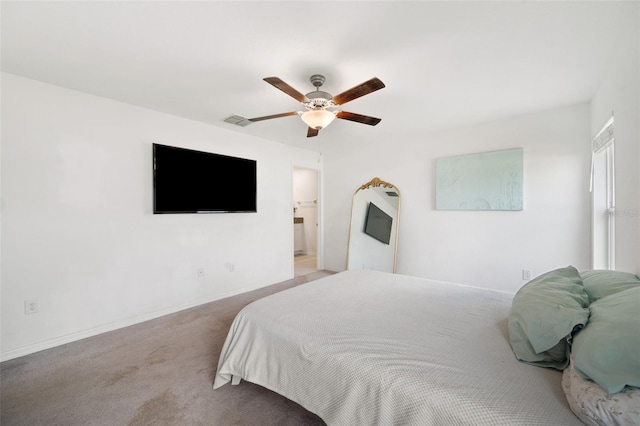 bedroom featuring light colored carpet, ceiling fan, and ensuite bathroom